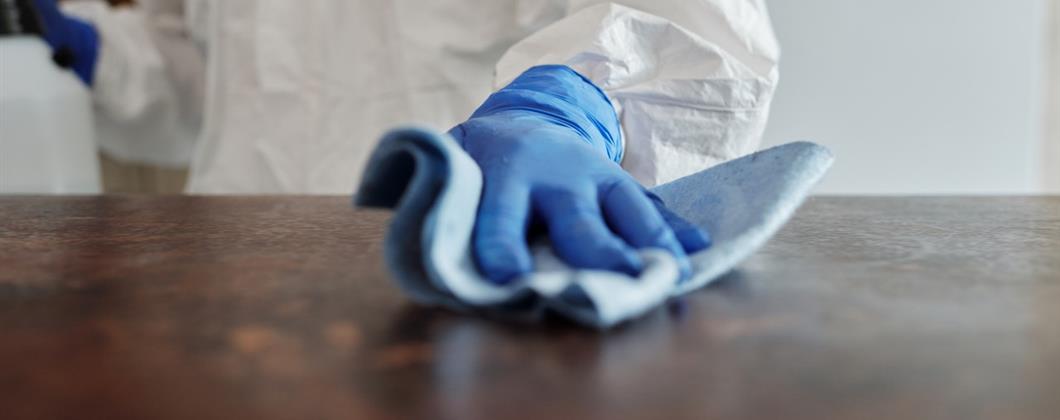 Business owner cleaning workplace surface 