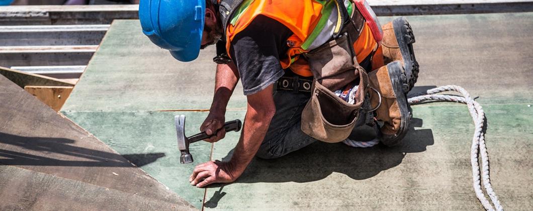 Construction customer working on a roof covered with Construction Insurance